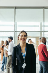 Cheerful woman at an office conference with colleagues in the background