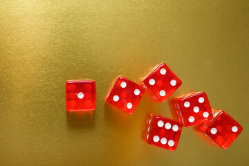Close-up of a red dice on a golden table