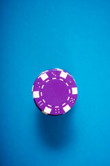 Purple casino chips on a blue surface