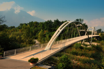 Fototapeta premium Modern Bridge over a River with Mountain in a Sunny Day in Ticino, Switzerland.