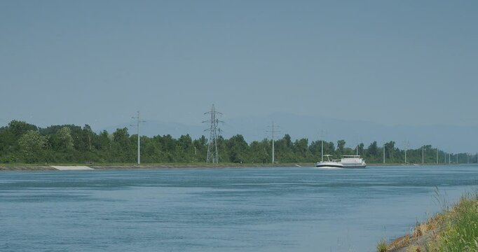 Navigation en p&eacute;niche sur le Grand Canal d'Alsace et du Rhin en direction de B&acirc;le en Suisse. Vue depuis la pointe la pointe sud de l'&icirc;le entre Allemagne et France
