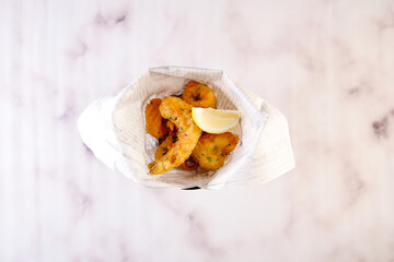 Fried Calamari and Shrimp with lemon slice served in dish isolated on grey background top view of italian fastfood