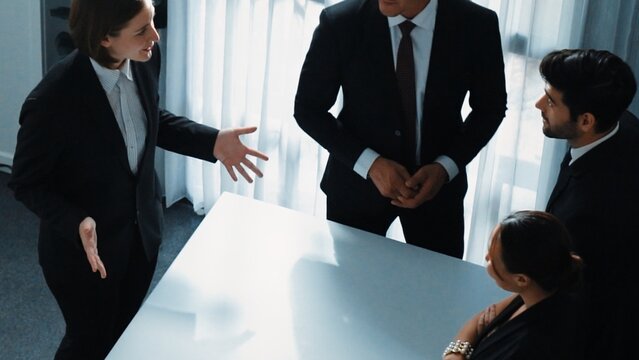 Top view of project manager looking at meeting table surrounded by diverse business people brainstorm and planning strategy. Group of smart people discussing and solve business problems. Directorate.