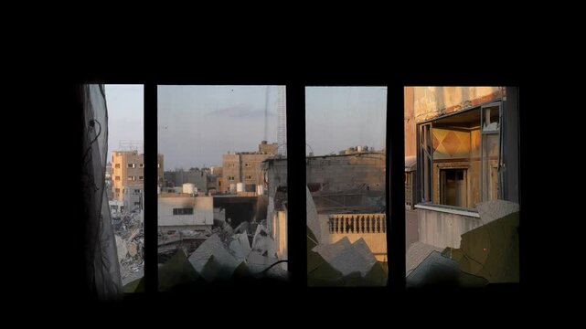 Damaged house window after Palestinians killed in Israeli shelling, View of bombed Gaza City from house window in Israel Hamas war conflict