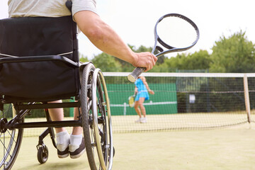 Person using wheelchair engages in tennis game, showcasing sports inclusion and motivation