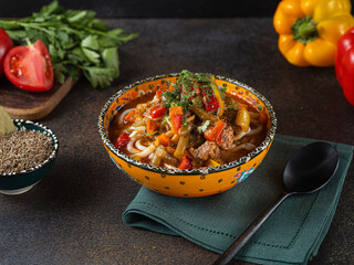 Delicious lagman soup, uzbek lagman soup, Asian cuisine, lagman soup with meat and vegetables. Lagman soup with beef, noodles, sweet peppers, onions and herbs.