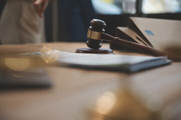 Judge gavel with Justice lawyers having team meeting at law firm background. Concepts of Law and Legal services.