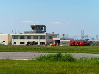 Fototapeta premium 空港化学消防車が並ぶ八尾空港の管制塔