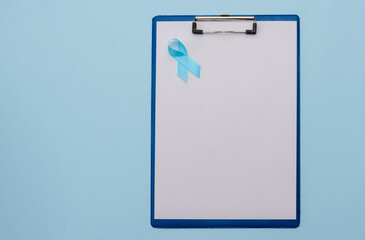 clipboard with blank paper and blue ribbon on blue background, prostate cancer awareness