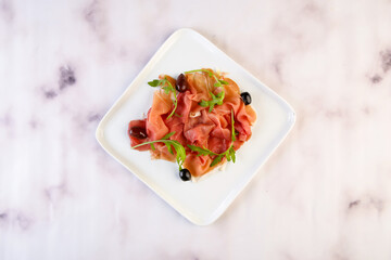 Parma Ham Plate with black olive served in dish isolated on grey background top view of italian fastfood