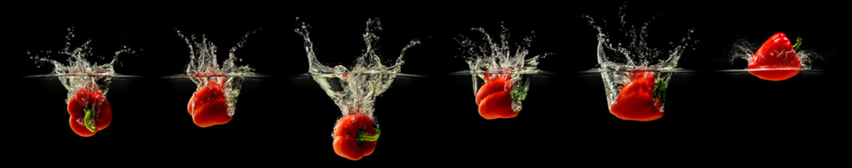 Group of bell pepper falling in water with splash on black background
