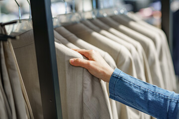 A girl chooses a men's suit for her man in a store in a shopping center.