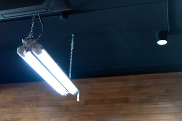 Long fluorescent tube ,LED bulbs and strips installed on the ceiling of a modern cafe