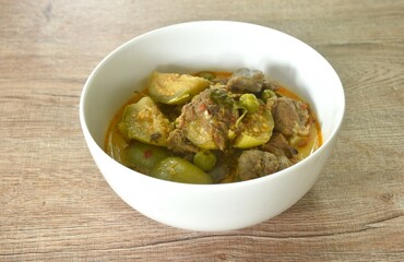 spicy boiled beef meat with eggplant in coconut milk red curry soup on bowl 
