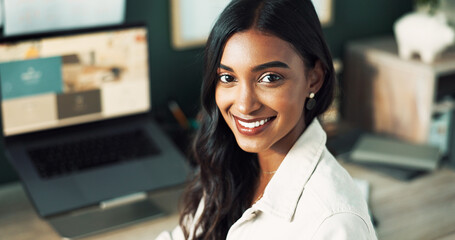 Portrait, business and Indian woman with laptop, smile and confidence in office for creative agency. Face, consultant and happy graphic designer with career ambition, website layout or online project
