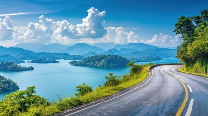 A beautiful long road with a beautiful view of a lake and mountains background