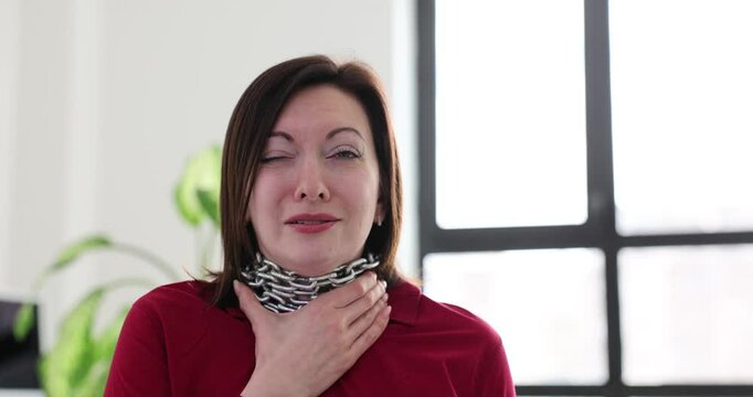 Woman bears weight of heavy metal chain wrapped around neck