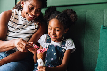 Happy black mother and daughter enjoying ice cream together
