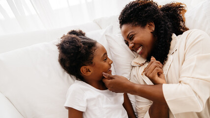 Obraz premium Mother and daughter bonding together in bed