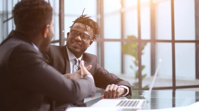 Serious young man supervisor analyse financial report of responsible worker pay attention on mistakes propose correction.