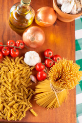 Pasta, table with pasta, ingredients and utensils, top view.