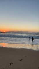 sunset in the sea people playing in water 