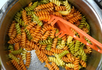 Three Colors Rotini Pasta. Pasta fusilli tricolore background. Abstract texture of colorful pasta....