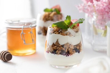 Yogurt with crispy granola, berries and honey for a delicious breakfast. Healthy eating.