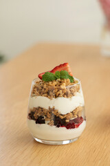 Yogurt with crispy granola, berries and mint leaves for a delicious breakfast. Healthy eating.