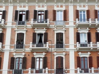 Apartment building facade with balconies and shuttered windows. Vintage Italian architecture