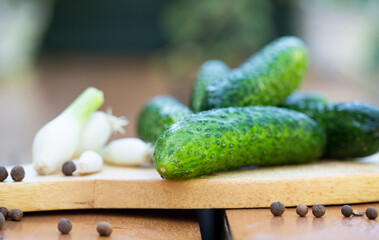 Fresh vegetables, green cucumbers and garlic on a wooden table