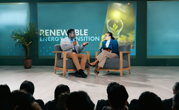 Man, woman and stage for interview at conference for renewable energy, solution and global policy. People, questions and talk in public debate for sustainability, future or plan of action for planet