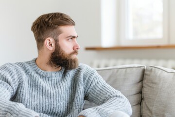 Fototapeta premium Thoughtful Bearded Man in Cozy Sweater Gazing Through Window