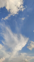 White fluffy clouds moving across a clear blue sky