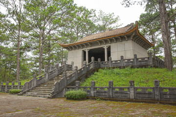 Nguyen Huu Hao stone mausoleum building with steps leading up to entrance located quietly in green...