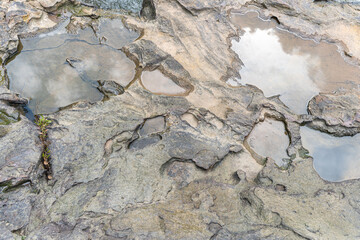 Rough brown stone wall with a natural texture, perfect for a background or landscape depicting a beach, volcano, or aged structure