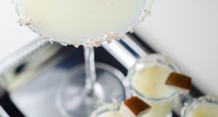 A martini glass with a garnish of coconut flakes on top