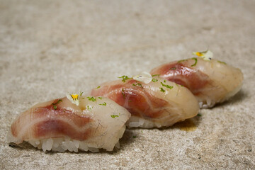 seabass nigiri with lime zest and edible flower 