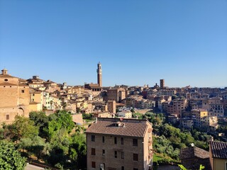 Overview of cityscape of Siena, Tuscany with Palazzo Pubblico, houses and churches on a sunny day...