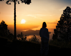 This captivating photo captures a golden sunrise over Lake Toba in Sumatra, Indonesia. The serene waters and lush hills create a tranquil scene, perfect for nature and travel enthusiasts seeking a bre