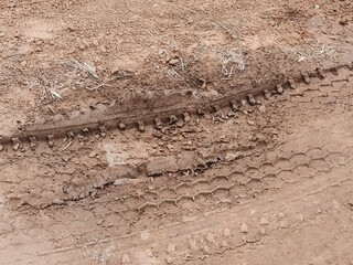 Tire tracks on light red soil.