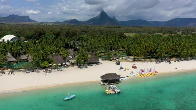 Aerial Landscape view of Flic en Flac beach with cityscape of Flic en Flac town and Mauritius mountain landscape in the background. Best tropical beaches in Flic en Flac, Mauritius island.