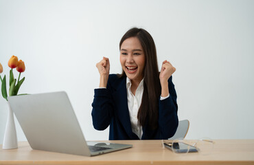 Portrait of a Young attractive Asian woman in a black business suit feeling euphoric celebration...