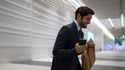 Happy business man celebrate his successful project while walking at white corridor. Project...