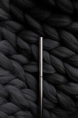 Mascara on a background of a gray merino wool blanket
