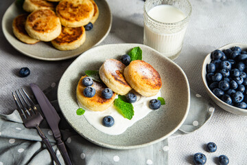Cottage cheese pancakes with cream sauce and blueberries. syrniki 
