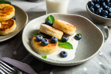 Cottage cheese pancakes with cream sauce and blueberries. syrniki 