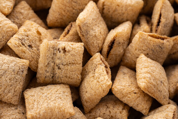 Corn snack. Cereal pads with filling falling into bowl against white background