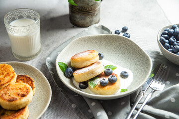 Cottage cheese pancakes with cream sauce and blueberries. syrniki 