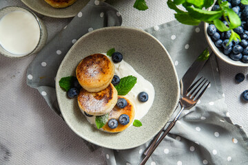 Cottage cheese pancakes with cream sauce and blueberries. syrniki 